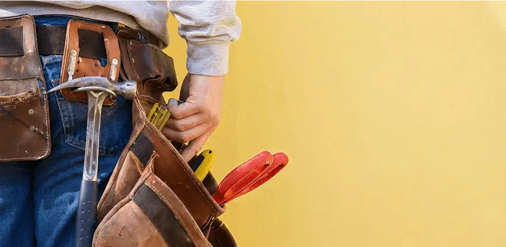 Handyman with tool belt ready for home repairs and maintenance in Nashua, NH