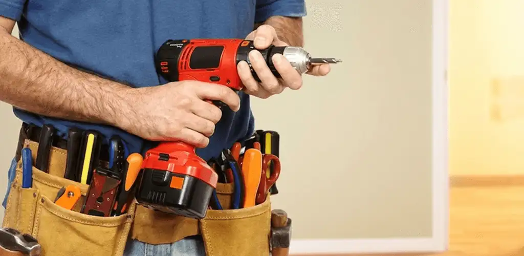Handyman holding a power drill for home repairs and installations in Nashua, NH