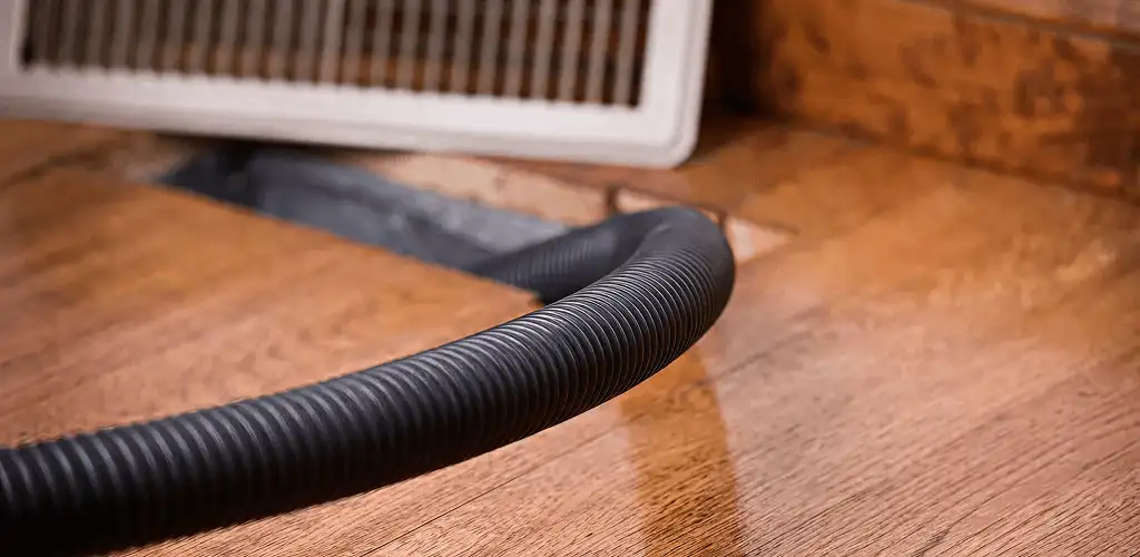 Air duct cleaning hose inserted into a floor vent for ductwork cleaning in Nashua, NH